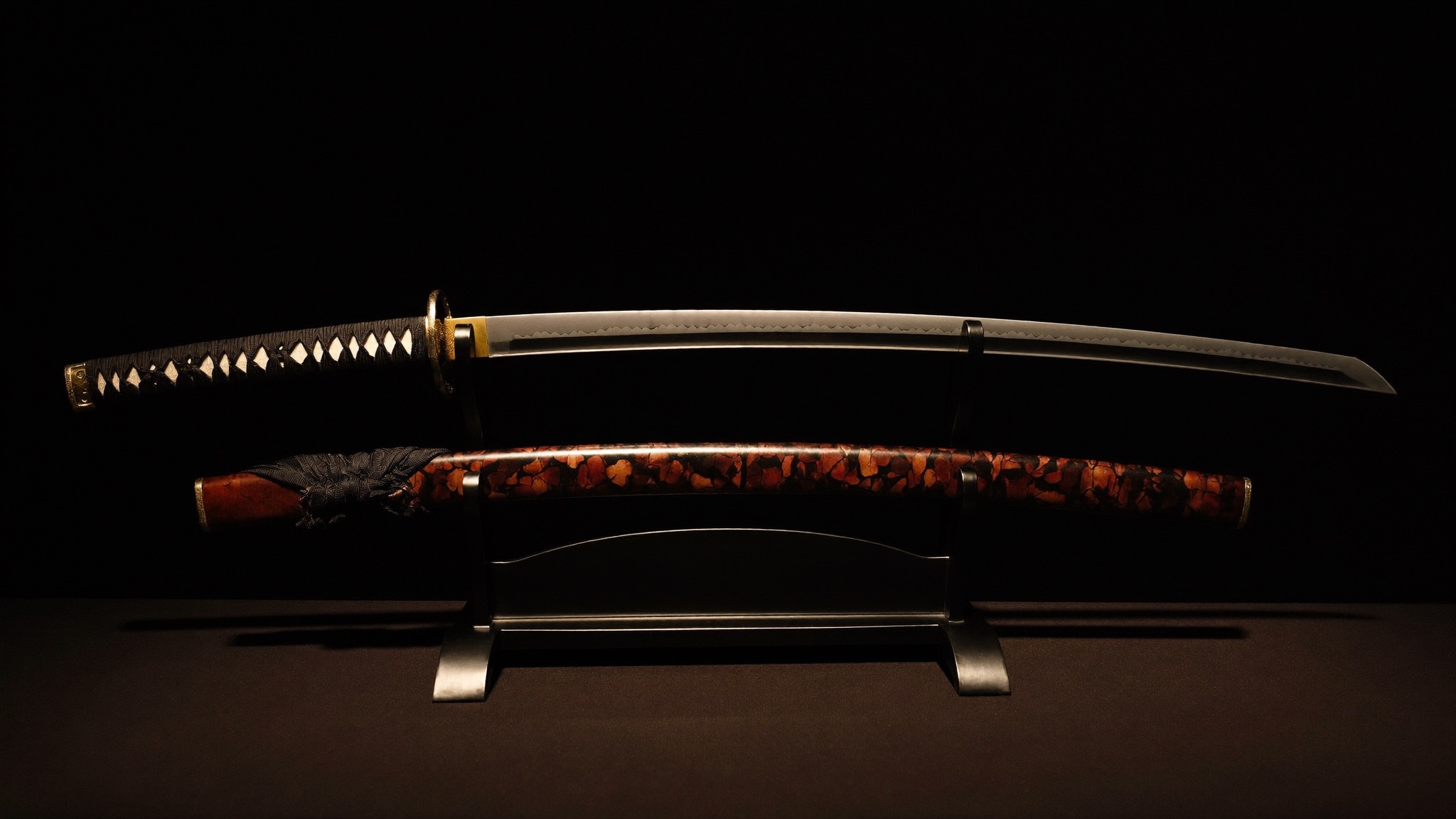 Katana resting on a black lacquer stand, its temper line caught in low warm light